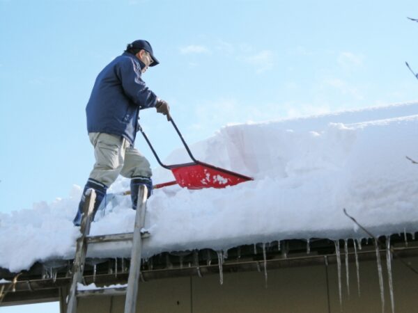 屋根の雪下ろしする男性　写真